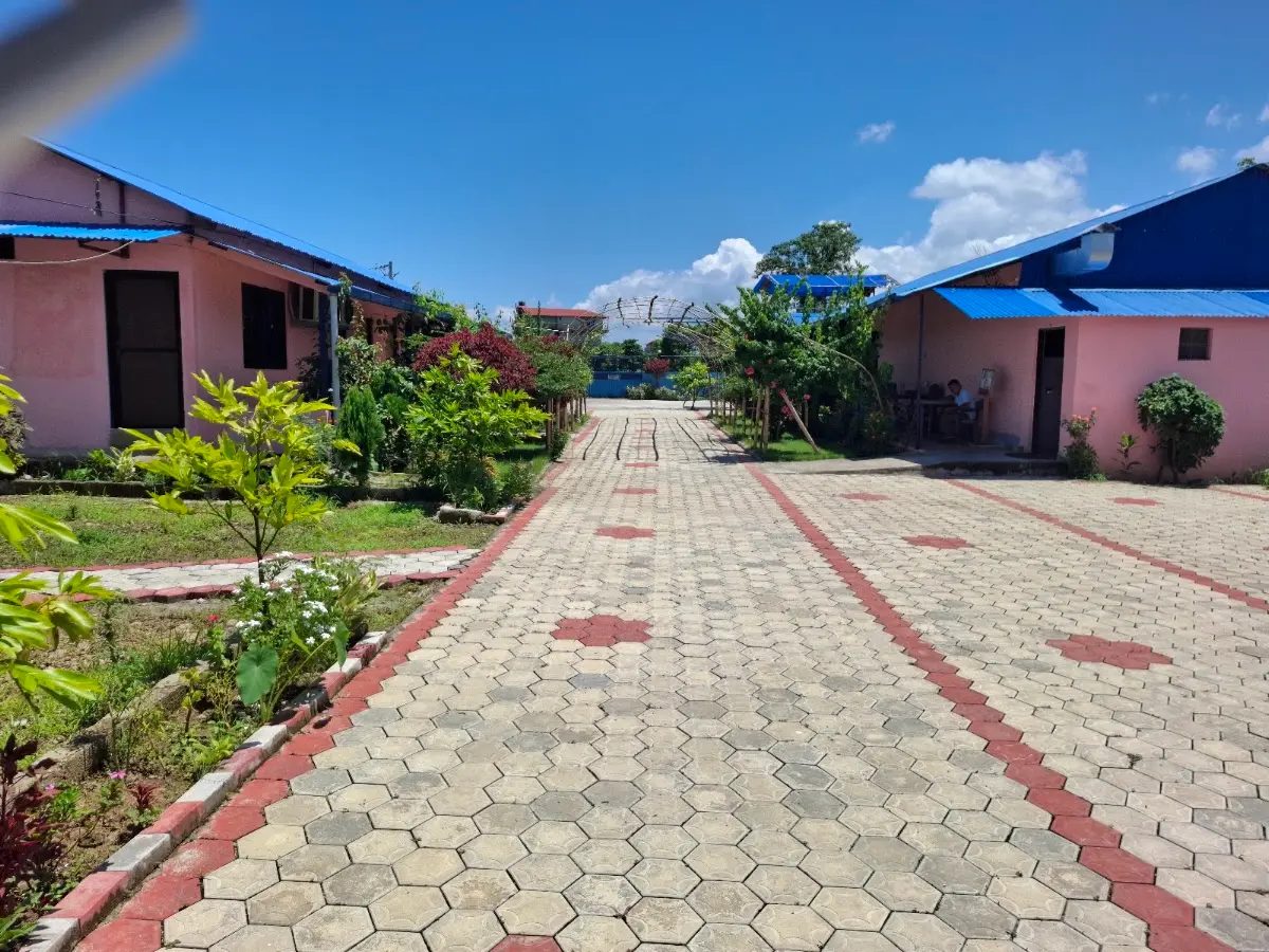 The cottages either side of the garden path at Sauraha Cottage